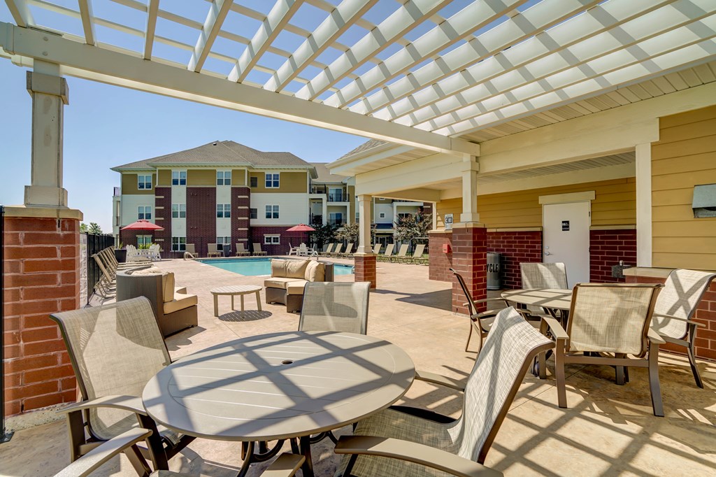 a patio with tables and chairs and a swimming pool